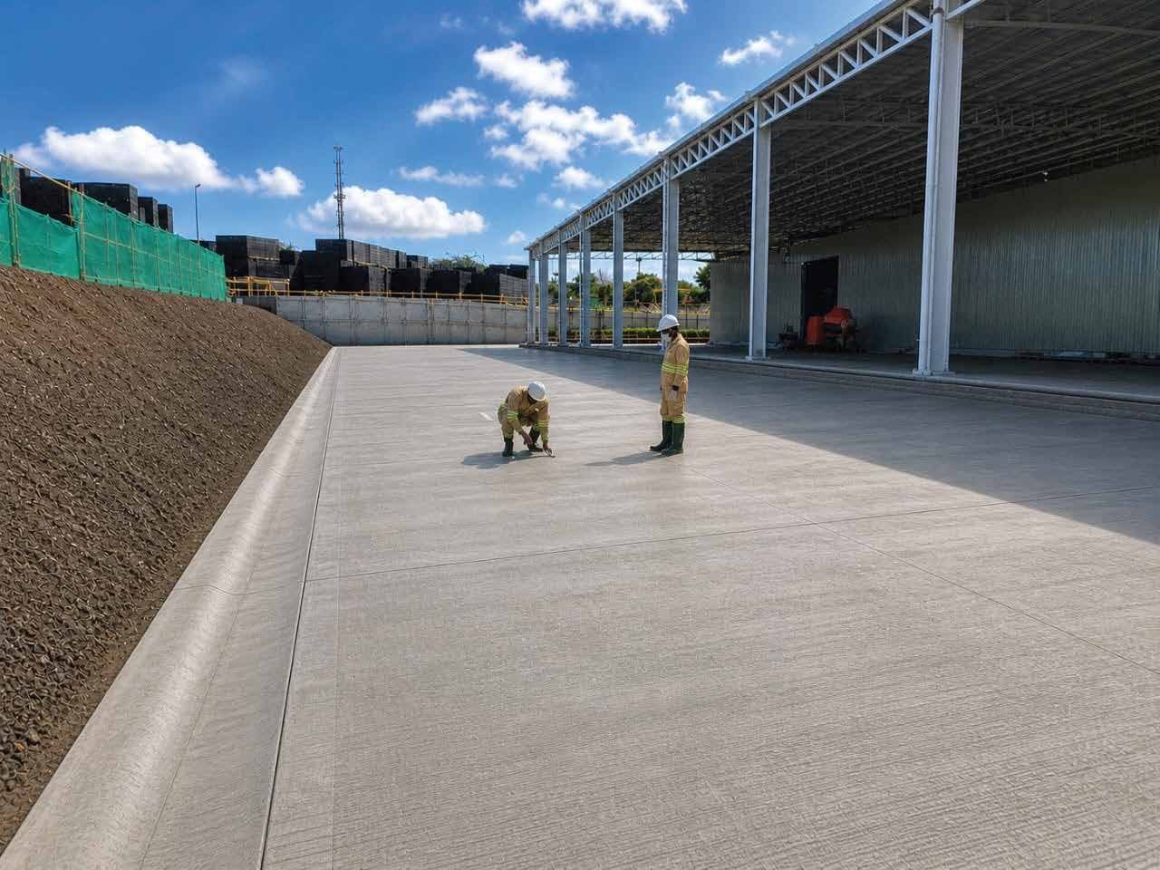 Engineers inspecting a finished concrete slab on site